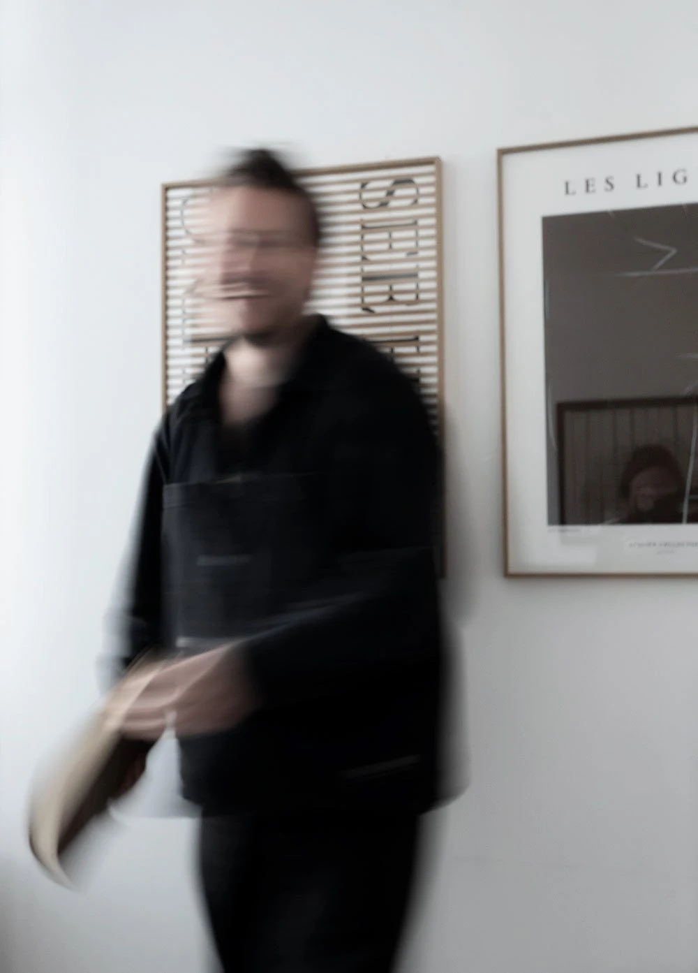 Vincent Templin, Art Director und Human Design Mentor des Holistic Playground, in Bewegung vor gerahmten Plakaten