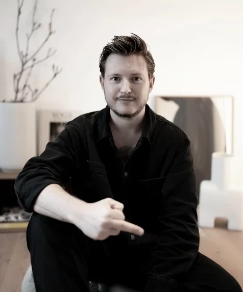 Vincent Templin, Art Director und Human Design Mentor des Holistic Playground, sitzend und lächelnd in seinem Studio